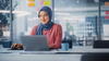 Woman sitting at a desk while working on a laptop